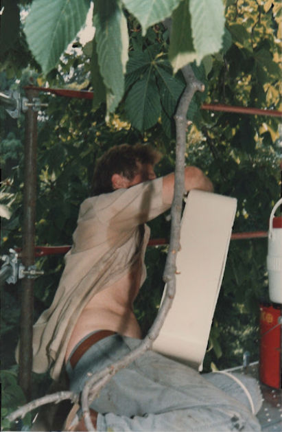 Carter working shirtless in dense summer foliage
